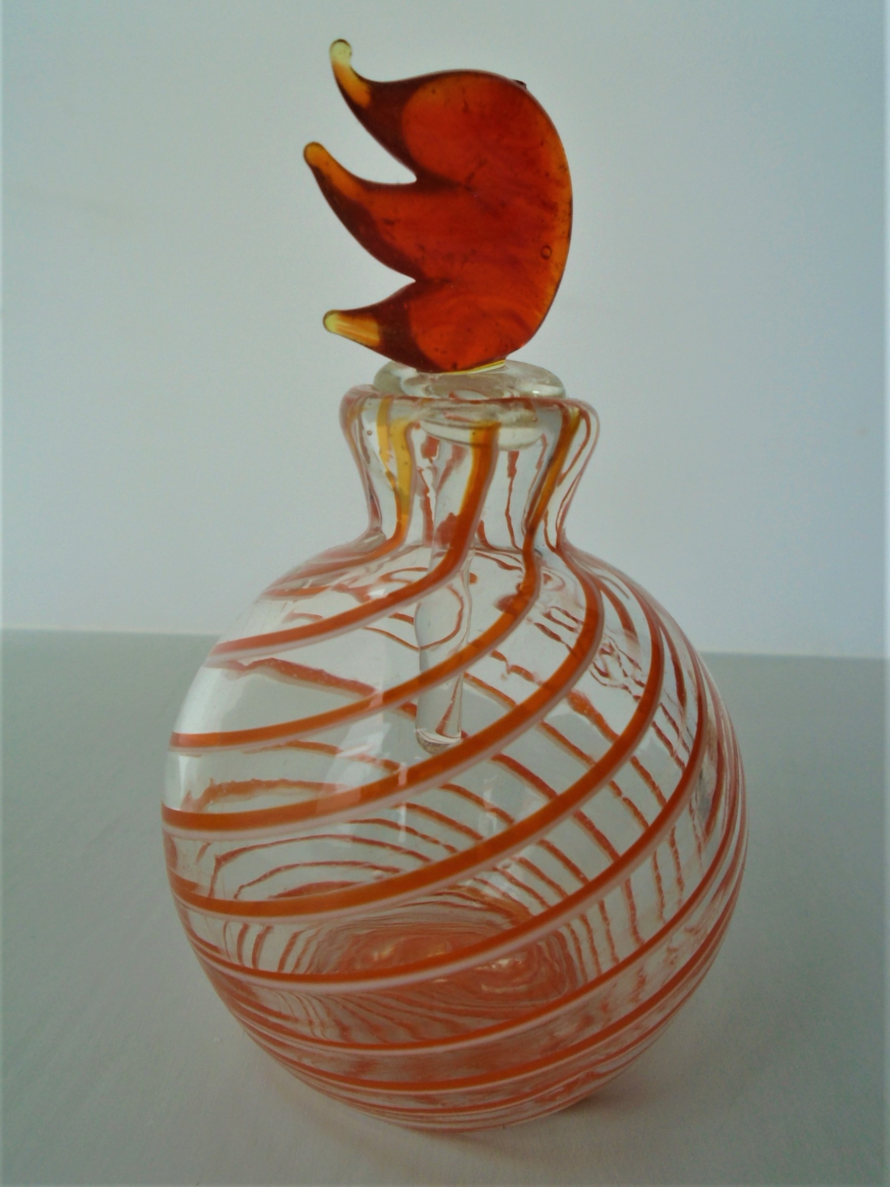 Offered for sale is a PRETTY GLASS PERFUME BOTTLE WITH  SPIRAL DECOARTION AND FLAME SHAPED STOPPER. 