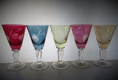 A collection of 5 different coloured glass liqueur glasses