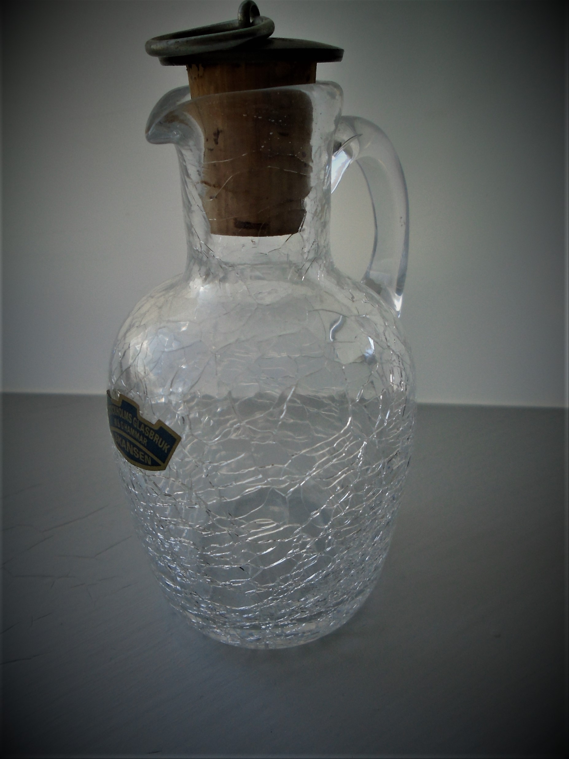 Offered for sale is STYLISH PIECE OF VINTAGE SWEDISH TABLEWARE IN THE FORM OF THIS CLEAR CRACKLE GLASS  JUG/PITCHER  with cork and embossed stopper.